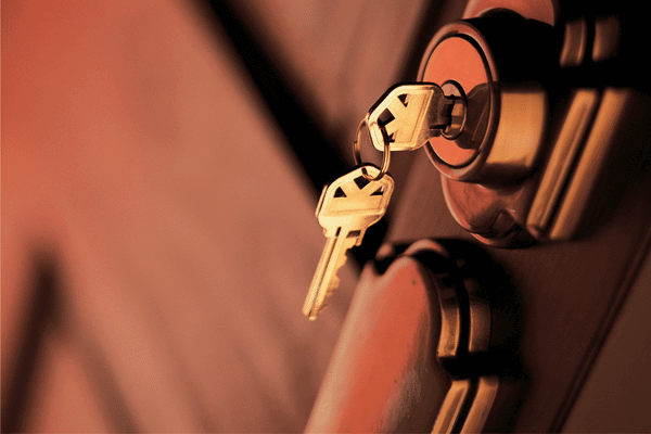 image shows keys dangling from a lock on a door