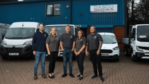 Team Dasco looking at the camera smiling in front of their premises in Wigan