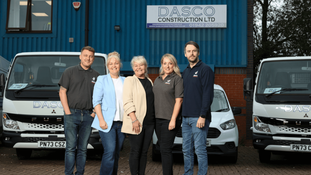 Team DASCO with Wigan Business Awards organisers smiling in front of their premises in Wigan