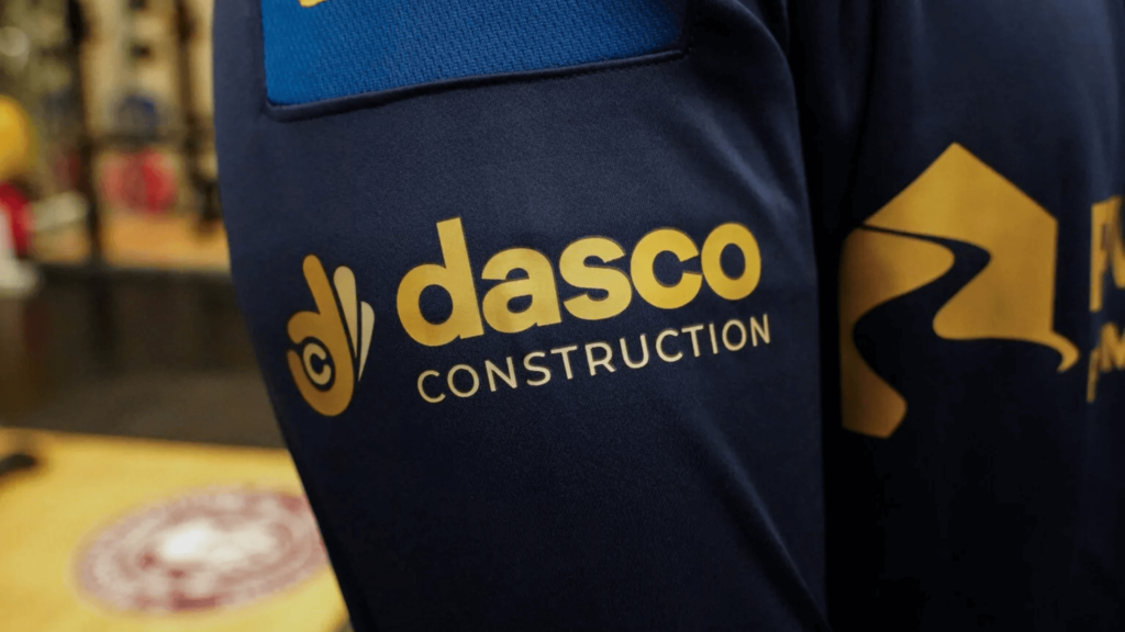 the dasco construction logo in the sleeve of a Wigan Warriors training shirt