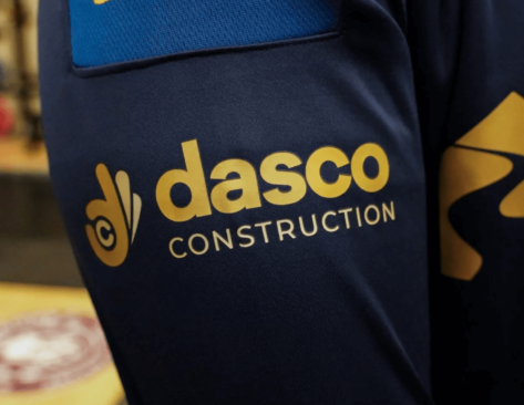 the dasco construction logo in the sleeve of a Wigan Warriors training shirt
