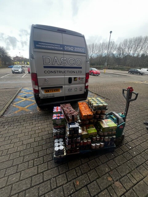 The back of a Dasco Construction van with a pallet of food on the floor