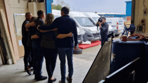 Picture of 4 Dasco team members with their arms around each other taken from behind.