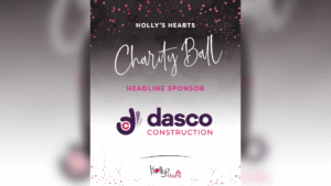 Promotional graphic for Holly’s Hearts Charity Ball featuring DASCO Construction as the Headline Sponsor. The design has a black to silver gradient background with pink glitter effects and white text reading “Holly’s Hearts Charity Ball”. The DASCO Construction logo is displayed prominently in the centre, with the Holly’s Hearts logo at the bottom. The overall design uses pink, white and purple branding with an elegant charity event theme.